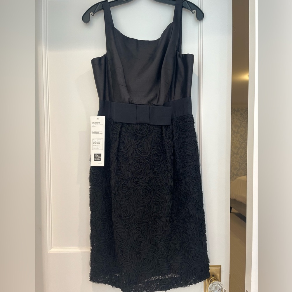 NWT black cocktail dress with lace bottom and bow detail at the waist. Size 8.